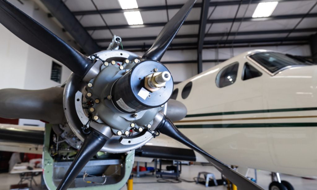 An image showing composite materials using high-tech equipment. The image includes a large sample of carbon fiber used in an aircraft propeller undergoing stress tests.