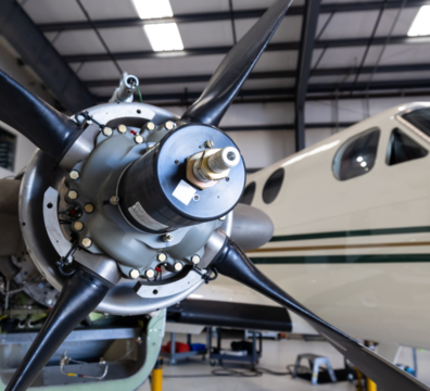 An image showing composite materials using high-tech equipment. The image includes a large sample of carbon fiber used in an aircraft propeller undergoing stress tests.